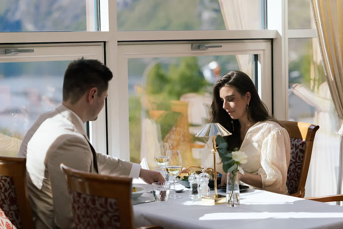 Par som spiser middag med utsikt mot Geirangerfjorden på Union Geiranger